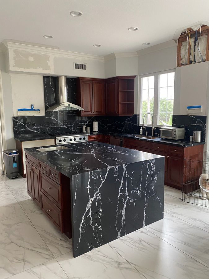 Kitchen island with dramatic black and white marble waterfall countertop