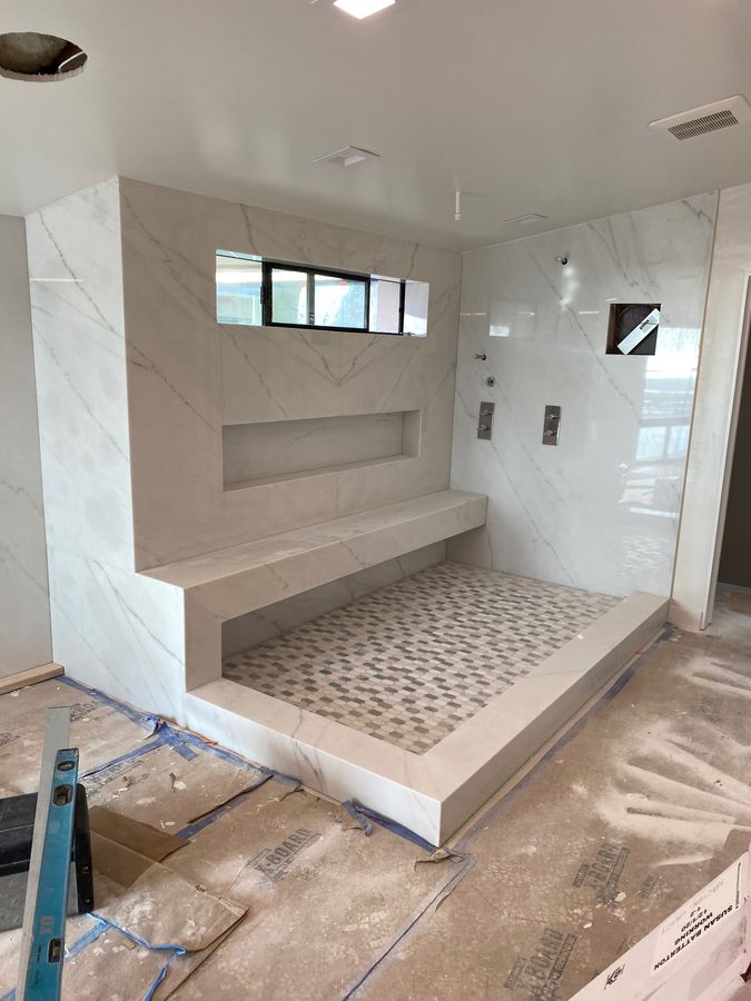 Marble shower enclosure with built-in bench and niche